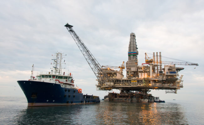 Oil rig being tugged in the sea